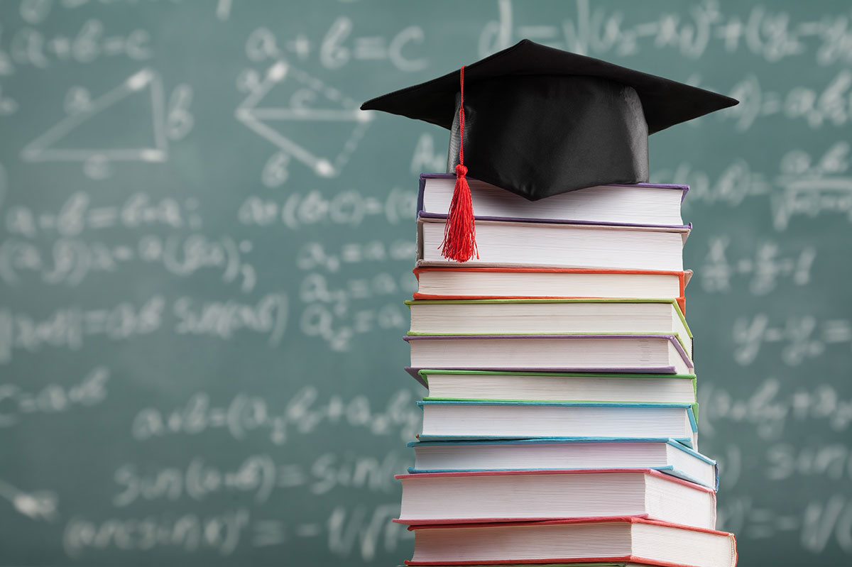 graduation cap on stack of books